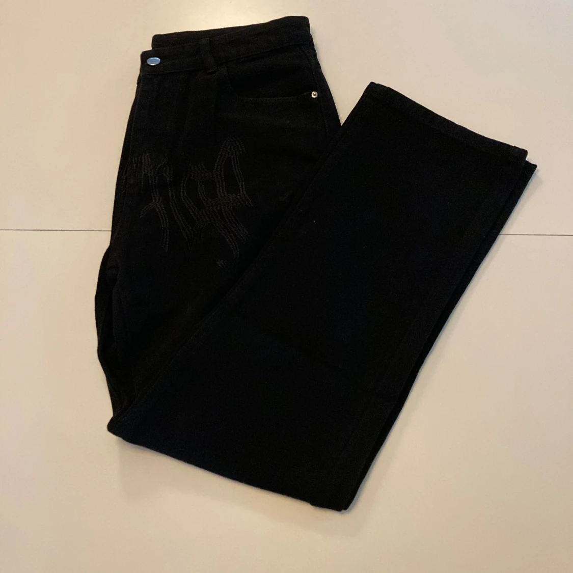 Svarta jeans med mönster på