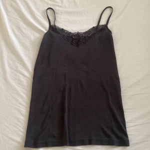 Svart linne från Vero Moda - säljer ett svart linne från Vero Moda i storlek L/XL men har krympt väldigt mycket så den är mera av en medium/small nu. fina spets detaljer runt halsen