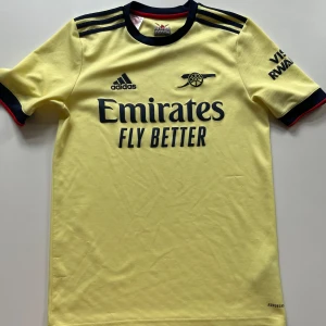 Arsenal matchtröja - Storlek 176. Har mindre skavanker som sett på bild, även en knappt synlig fläck. Annars bra skick. Adidas. 