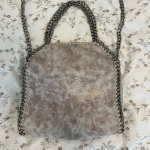Stella McCartney liknande väska - Super fin beige/ljusrosa skimrig Stella McCartney liknande väska😍 säljer då jag inte använder länge. Pris går att diskutera🥰
