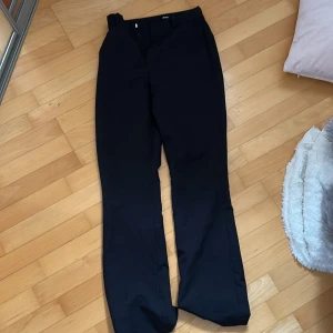 Svarta kostymbyxor - Säljer ett par stilrena svarta kostymbyxor. De har en klassisk design med raka ben och en elegant passform. Perfekta för både formella tillfällen och kontoret. SMÅ i storlek