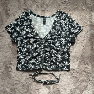 Svart topp - Topp i svart och vitt mönster, med schrunch möjlighet i fram 