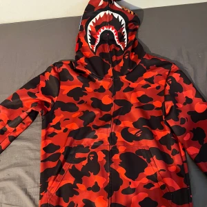 Röd och svart camo hoodie med hajmotiv - Säljer en bape kofta ej original använd få gånger 