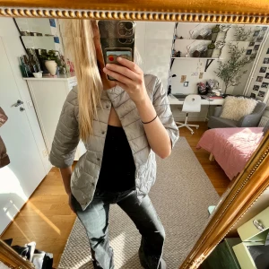 Grå pufferjacka - Säljer en snygg grå pufferjacka med trekvartsärm. Perfekt för höst och vår när det är lite kyligt ute. Jackan är köpt secondhand och om du har några fler frågor är det bara att kontakta mig 🌸