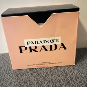 Paradoxe Eau de Parfum från Prada - Säljer en elegant och lyxig parfym, Paradoxe från Prada. Förpackningen är i en stilren ljusrosa färg med svart text. Den innehåller 90 ml av en underbar doft som är både påfyllningsbar och i sprayform. Perfekt för den som vill ha en sofistikerad och modern doftupplevelse.