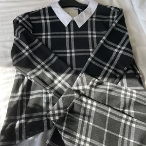 Svart och vit rutig klänning från FB Sister - Säljer en superfin svart och vit rutigt sätt från new yorker. Tröjan har en klassisk vit krage som ger en preppy look. Kjol med kommer också som är matchande till!! Materialet känns bekvämt och har en snygg passform. Perfekt för utekväll med tjejerna