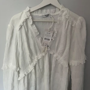 Vit blus NAKD - Säljer denna jätte fina vita oanvända blusen från NAKD💕, aldrig använd så toppskick, säljer då jag råka köpa 2 och retur tiden gick ut, strlk 40💕nypris 399kr