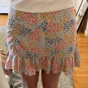 Färgglad sommar kjol  - Det är en kortare kjol med färg glada blommor! Den är i bra material och väldigt fin!