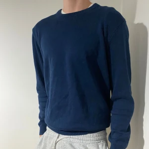 Mörkblå ZARA tröja - Säljer en stilren mörkblå tröja i bomull. Den har en klassisk rund hals och långa ärmar, perfekt för både vardag och lite finare tillfällen. Tröjan är i bra skick och passar perfekt till jeans.