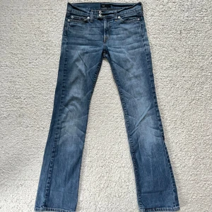 Lågmidjade bootcut jeans  - Snygga bootcut jeans med låg midja och fin detalj vid knäppningen! Storlek w27 L33   midjemåttet 2x37 cm   innerbenslängden 80 cm
