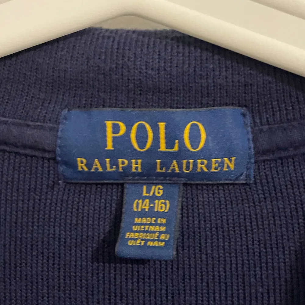 Säljer en snygg mörkblå tröja från Polo Ralph Lauren. Den har en dragkedja vid halsen och det klassiska röda logotypbroderiet på bröstet. Tröjan är långärmad och perfekt för både höst och vinter. Den är i bra skick och passar perfekt till jeans för en avslappnad stil.. Tröjor & Koftor.