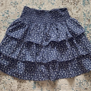 Kjol med volanger  - Kjol med volanger i blommigt mönster. Jättefin till sommar och höst💙🤍Nyskick!