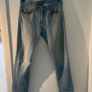 Levi's 501 jeans i ljusblå färg - Säljer ett par klassiska Levi's 501 jeans i en snygg ljusblå tvätt som har en rak passform. Finns inga tydliga tecken på användning utan har använts sparsamt (skick 8/10). Hör gärna av er vid frågor eller funderingar!