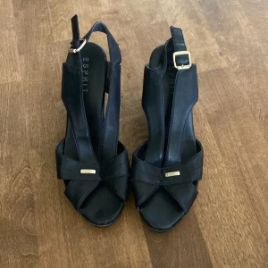 Kilklackar - Söta kilklackar från esprit. Köpta på sellpy men säljer pga fel storlek. Svarta med guldiga detaljer, storlek 39. Kan mötas i stockholm om önskas🤍🤍