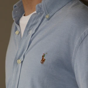 Ralph Lauren Oxford skjorta blå - Slim Fit Polo Ralph Lauren Oxford blue skjorta.  Storlek: S   Skick: Nyskick, endast provad Nypris: 1599 kr Modellen är 175cm och 60kg   Mått i cm  Ärmlängd: 85. Bröstvidd: 92. Midjevidd: 86. Plagglängd: 76.  Tveka inte på att höra av dig vid frågor.