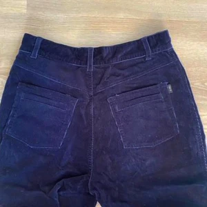 Mörkblå manchesterbyxor från Zara - Säljer ett par snygga mörkblå manchesterbyxor från Sara. De har en klassisk design med raka ben och en bekväm passform. Byxorna har praktiska fickor både fram och bak samt en dragkedja och knapp i midjan. Perfekta för höst och vinter!