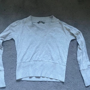 Grå tröja  - En långärmad tröja, inte så tjock i materialet så det går bra att ha ett linne eller T-shirt under om man vill❣️inga skador mm.