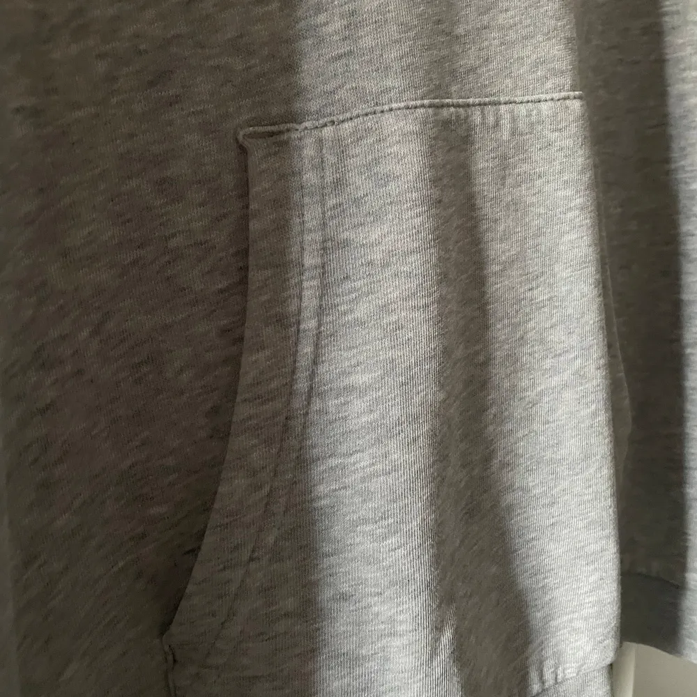 Säljer en grå hoodie från Sail Racing. Den är superbekväm och perfekt för kyliga dagar. Hoodien har en stor ficka på magen och en snygg logga på bröstet. Den är i bra skick och passar perfekt för både vardag och träning. Köp den nu eller ge ett bud! 💛. Hoodies.