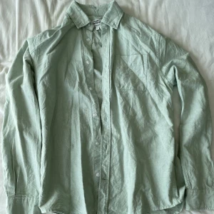 Ljusgrön skjorta från Hampton Republic - Säljer supersnygg skjorta från Hampton Republic i storlek S. Skjortan är i regular fit och har långa ärmar. Den är tillverkad i ett mjukt och bekvämt material, perfekt för både vardag och fest. Skjortan har knappar hela vägen ner och en bröstficka på vänster sida. Premium. Frågor? Skriv!
