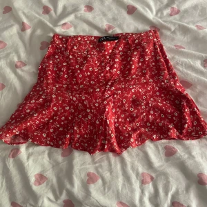 Röd blommig kjol från Zara - Säljer en superfin röd kjol från Zara i storlek S med ett sött blommönster. Kjolen har shorts under så man slipper ha cykel byxor.💕💕