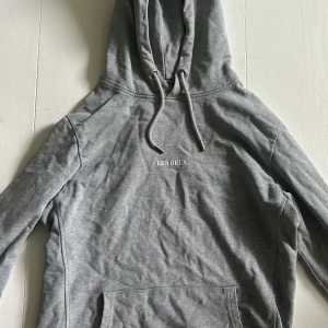 Grå hoodie från Les Deux - Säljer en snygg och bekväm grå hoodie från Les Deux. Den är i storlek S och har en klassisk design med en känguruficka och justerbar huva med dragsko. Tröjan är i ny skick. Hör av er för fler frågor. MVH Frasse!