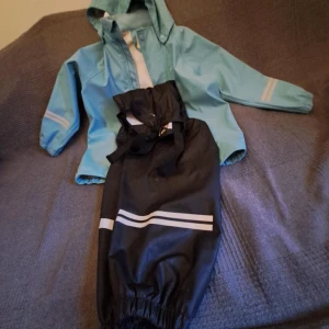 Svarta byxor från Kaxs - svarta byxor med reflexband och justerbara hängslen. Perfekt för regniga dagar! 🌧️