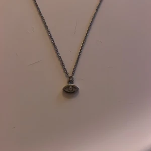 Silverhalsband med ögonberlock - Silvirit halsband med ögon berlock på med en diamant i mitten 