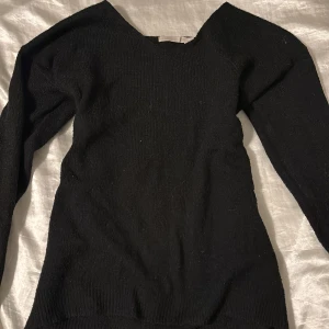 Svart stickad tröja - Säljer en stilren svart stickad tröja med långärmad design. Perfekt för kyligare dagar och enkel att matcha med olika outfits.
