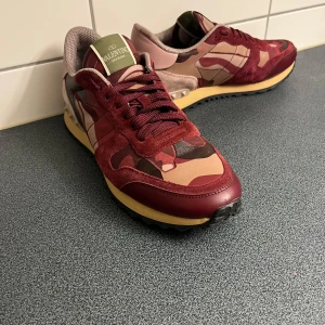 Valentino Rockrunner sneakers i vinrött - Snygga Valentino Rockrunner i vinröd. Storlek 41 men passar 40 med. Svart smuts på den högra skon. Pris kan diskuteras 