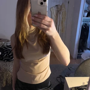 Beige ärmlös topp - Säljer en superfin beige topp som passar både till vanliga outfits och finare tillfällen, bra till både kjol och byxor💗💗💗kroppsnära form också vilket gör tröjan ännu finare