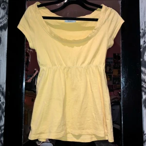 Söt topp från Gina Tricot - Säljer en söt gul topp från Gina Tricot i ekologisk bomull. Toppen har korta ärmar och en rundad halsringning. Perfekt för en solig dag!