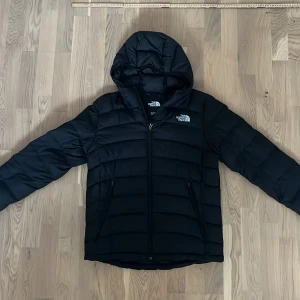 Svart dunjacka från The North Face - Säljer en svart dunjacka från The North Face . Den är stilren och funktionell med logotyp på bröstet. Strl M