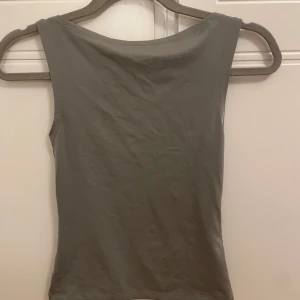 Grå topp från Weekday(storlek xs) - Säljer en stilren grå ärmlös topp från Weekday i storlek XS. Perfekt för en minimalistisk look och lätt att matcha med andra plagg. 