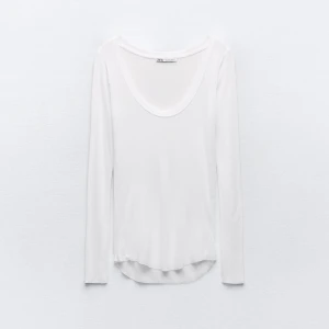 Vit långärmad topp från Zara - Säljer en stilren vit långärmad topp från Zara. Perfekt basplagg med rund halsringning och mjukt material. Passar till många olika outfits och tillfällen.