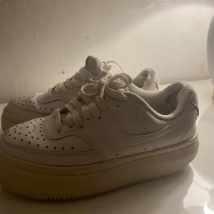 Vita sneakers - Säljer ett par vita sneakers med snörning och detaljer på ovansidan. 