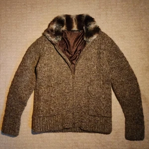 Pälsfodrad cardigan  - Säljer en väldigt mysig stickad Cardigan i fantastisk kvalitet, Perfekt nu inför lite kallare väder. Cardiganen är fodrad och har en kvalitativ pälskrage i mycket fin päls samt dubbel dragkedja vilket ger en stilren och unik design. Väldigt fint skick utan några som helst defekter. Skriv vid minsta fundering!