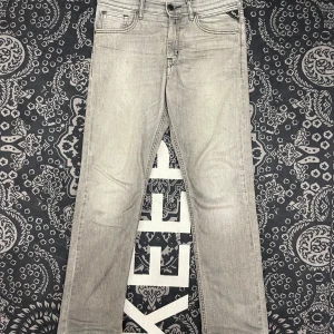Grå jeans från Replay - Snygga grå jeans från Replay med klassisk femficksdesign och diskreta sömmar. De har en rak passform och är perfekta för en stilren look. Märkeslappen på baksidan ger en extra touch av stil.
