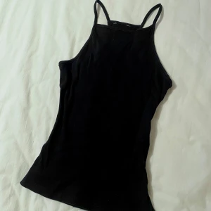Svart ärmlös linnetopp - Snygg svart ärmlös linnetopp med smala axelband. Enkel och stilren design som passar till det mesta. Kontakta mig om du undrar över något ☺️