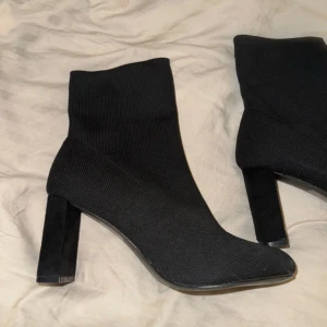 Svarta boots med klack - Snygga svarta boots i stretchigt material med hög klack. Perfekta för en stilren look. 