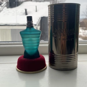 Le Male Parfym från Jean Paul Gaultier 40ml - Säljer en ikonisk Le Male parfym från Jean Paul Gaultier. Flaskan har en unik design i form av en manlig torso i blått glas med horisontella ränder. Kommer med en metallisk förpackning som ger en lyxig känsla. Perfekt för den som vill ha en klassisk och tidlös doft.
