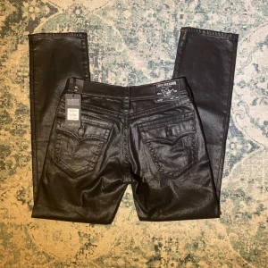 Svarta jeans från True Religion - Svarta vaxade jeans från True Religion. Köpta i LA på en True Religion butik 2020 men har aldrig kommit till användning. Nya med prislapp.  