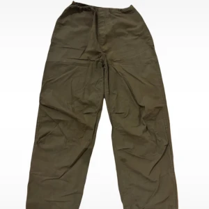 Stradivarious Green Parachute Pants 💚 - Säljer ett par olivgröna byxor med resårmidja och raka ben. Byxorna har en avslappnad passform och är perfekta för en bekväm stil. De har bakfickor och justerbara benslut.