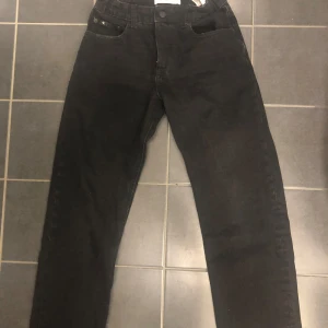 Svarta jeans från Calvin Klein - Säljer ett par snygga svarta jeans från Calvin Klein i storlek 14. De har en klassisk femficksdesign och en stilren look. Perfekta för både vardag och fest! 🖤