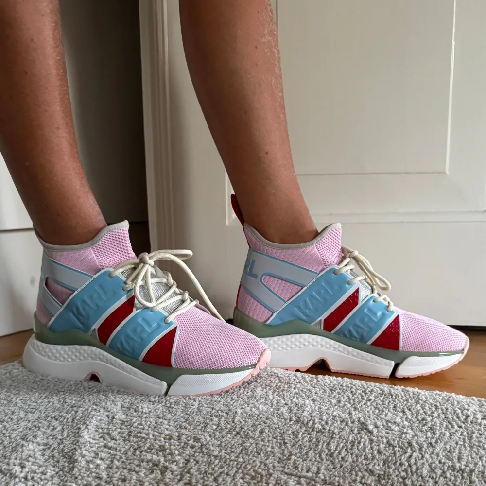 Säljer ett par supercoola sneakers från Karl Lagerfeld i rosa, blått och rött. De har en unik design med snörning och en bekväm sula. Perfekta för att liva upp vilken outfit som helst! Använda men i bra skick.. Skor.