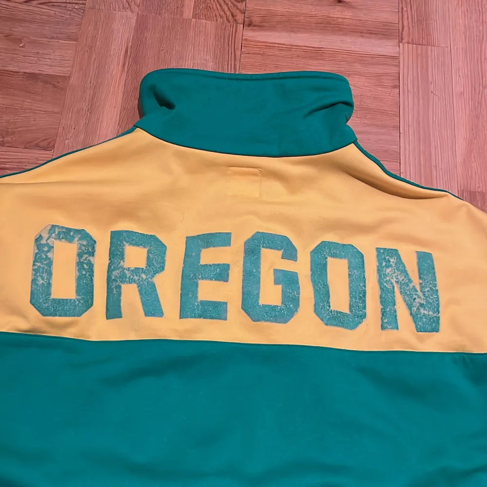 RIKTIGT fet adidas zip i gult och grönt. Oregon färgtema. Helt felfri utom lite slitage på texten över ryggen. Storlek L enligt etiketten men skulle säga att den sitter M. Fråga gärna om mått eller fler bilder!!!. Tröjor & Koftor.