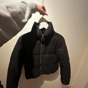 Svart pufferjacka från ONLY - Säljer en snygg svart pufferjacka från ONLY i storlek XS. Jackan har en dragkedja framtill och är perfekt för kyliga dagar. Den är croppad och har en modern look som passar både till vardags och fest. Perfekt för höst och vinter! 🖤säljer den då den inte passar mig längre i storlek