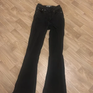 Svarta bootcut jeans - Säljer ett par svarta bootcut jeans i storlek XS. De har en klassisk femficksdesign med knappar och dragkedja framtill. Perfekta för både vardag och fest! 🖤