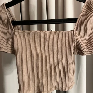 Beige ribbad topp - Beige brun ribbad topp med korta puffärmar. Aldrig använd så väldigt bra skick.🩷