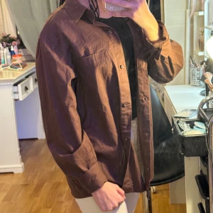 Brun skjorta från H&M Divided - Säljer en snygg brun skjorta från H&M Divided i storlek XS. Skjortan har långa ärmar och knappar framtill. Perfekt för höst och vår, och kan stylas både uppklätt och avslappnat. Materialet känns bekvämt och passar bra till olika outfits. 🧡