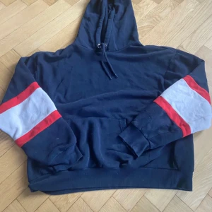 Monki hoodie - Perfekt nu inför hösten!🍂🍁 Mörk blå hoodie från monki med röda och vita detaljer på ärmarna. 